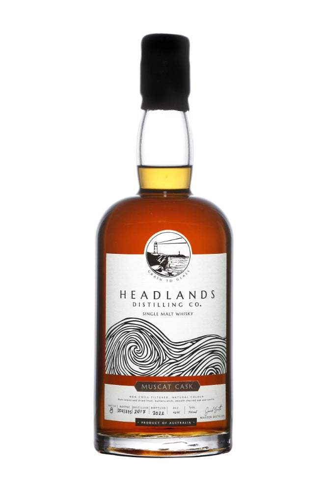 Headlands Distilling Co. Muscat Single Malt Whisky 700ml bottle with label and glass, showcasing rich amber color and elegant packaging.