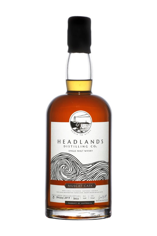 Headlands Distilling Co. Muscat Single Malt Whisky 700ml bottle with label and glass, showcasing rich amber color and elegant packaging.
