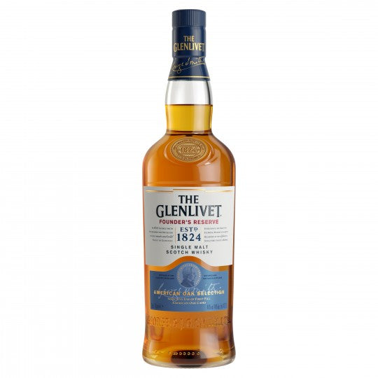 Glenlivet Founders Reserve Scotch whisky in a 700ml glass gift pack with a branded whisky glass, displayed on a wooden surface.