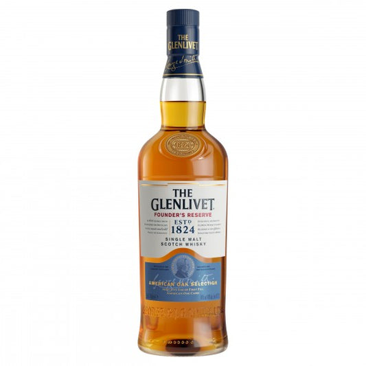 Glenlivet Founders Reserve Scotch whisky in a 700ml glass gift pack with a branded whisky glass, displayed on a wooden surface.