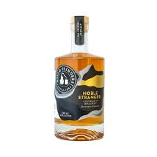 Australian brandy in a 700mL bottle, Bass & Flinders Noble Stranger by Paramount, with a dark amber liquid in a glass.